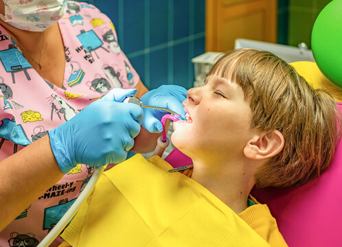 The dentist is carrying out the sanitation of the boy's oral cavity. Children stomatology.