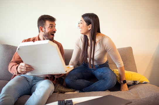 Couple on sofa with pizza