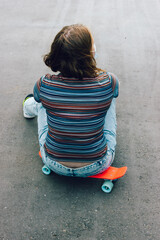 Summer lifestyle image of trendy pretty girl sitting on quay on the urban background.