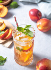 cool peach tea with mint and ice in a glass on a blue background. Top view  and close up