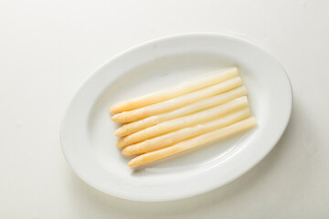 Espárragos  blancos sobre plato en fondo blanco. White asparagus on plate in white background.