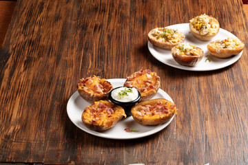 Patatas gratinadas  c on queso, jamón y Verduras sobre mesa de madera. Potato gratin with cheese,...