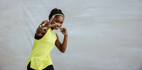 African sportswoman showing peace gesture using hand
