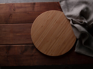 Tabla redonda de madera sobre mesa de caoba. Round wooden board on mahogany table.