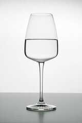 Elegant crystal glass filled with pure water on a white background. Glassware for red or white wine. Bars equipment, restaurants, beverages, lifestyle.