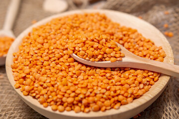 Orange lentils in a wooden bowl. selective focus. Rustic style
