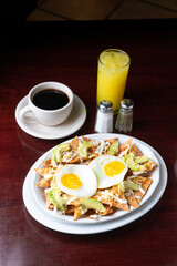 nachos with fried eggs with orange juices and coffee
