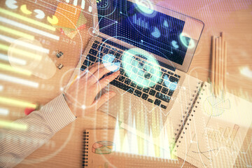 Multi exposure of man's hands typing over computer keyboard and data theme hologram drawing. Top view. Technology concept.