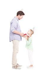 Vertical full length side view shot of modern loving father giving gift box to his cute daughter, white background