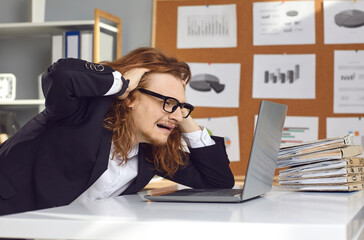 Stressed young man having computer problem at work. Crazy office manager worrying whether business...