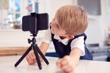 Boy At Home Wearing School Uniform Making Video Call On Mobile Phone