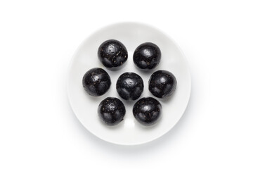 Black sesame ball in a plate isolated on white background. Chinese snack. Top view.