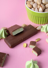 layout with free space for your text. Pink background with a jar of pistachios and Protein Bars in Chocolate. sweets and snacks