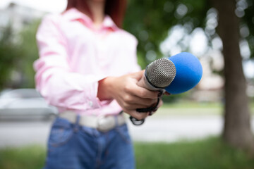 What is your storry? Journalist at news conference, writing notes, holding microphones