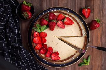 cream cheesecake with strawberries, mint and chocolate. portions of dessert on a dark background 