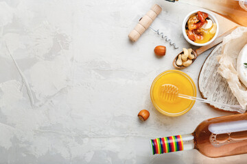 Rose wine pink wine bottle with appetizer set for romantic dinner on light gray stone background. Mediterranean food drinks for wine party dinner.