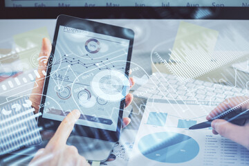 Double exposure of man's hands holding and using a digital device and tech theme hologram drawing. Technology concept.