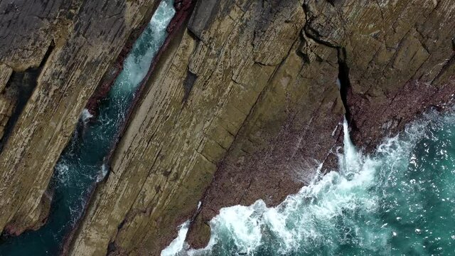 Aerial view of scenic beach with a rocky promontory and green water. Saturraran Hondartza, Saturraran Punta, Ondarroa, Basque Country.