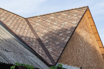 Repair, construction and building materials, wooden roof of the building covered with soft flexible...