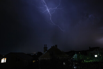 Naklejka na ściany i meble Beautiful lightning flashes in the evening sky during a thunderstorm