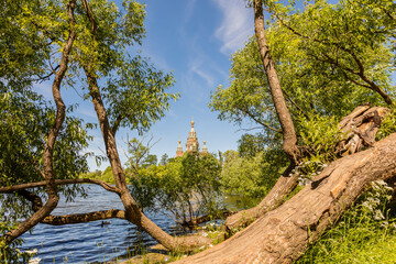 A magnificent landscape with a view of a tree by the pond and a church.