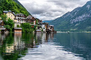 Fototapeta na wymiar View of traditional houses in Hallstatt, Austria. Reflections in the Lake on a summer day with overcast