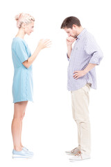 Vertical full length side view studio shot of angry young adult woman quarrelling with her husband, white background