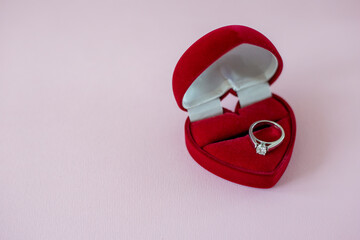 Diamond ring in a red heart-shaped box. Engagement ring with solitaire dimond. Proposal of marriage