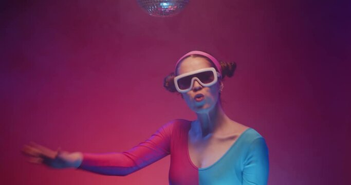 Retro disco woman 80s dancer on the dance floor in colorful tracksuit and stylish sunglases. Funny vintage retro people dancing at club party under disco ball