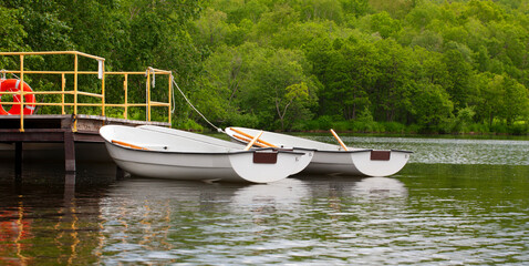 boats with oars near the pier on the lake
