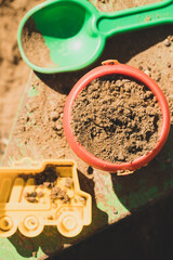 Bucket With Sand, Shovel And Form On Sandpit In Spring Top View.