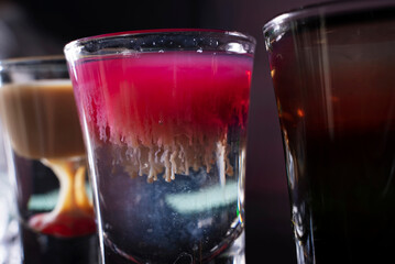 Barman preparing cocktail shots at the bar counter. Barman mixing drinks at the night club..
