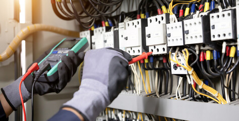 Electrician engineer tests electrical installations and wires on relay protection system....