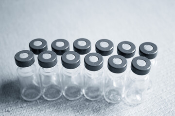 Empty glass jars of coronavirus vaccines