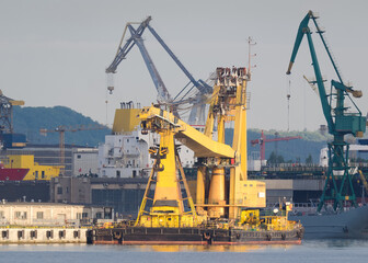 Fototapeta na wymiar CRANE SHIP - A specialized yellow machine moored at the quay of seaport 