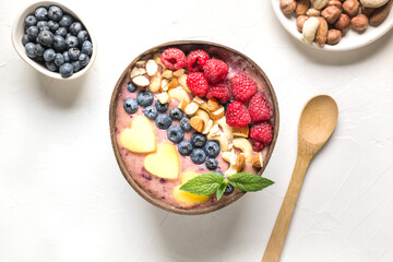 Banana and blueberry smoothie for healthy breakfast in coconut bowl isolated on white background. View from above. Clean eating, vegan food. Without sugar.