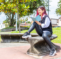 young woman laughing while reading in a notepad