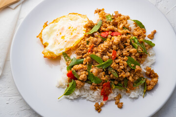 Close up Stir fried Thai basil with minced pork and a fried egg on white plate