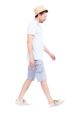 Vertical full length side view portrait of handsome bearded Caucasian man wearing summer outfit with hat walking somewhere, white background