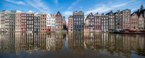 Panoramic view of traditional houses along the Damrak canal in Amsterdam, Netherlands