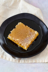 Organic honeycomb on wooden background. honey on the plate