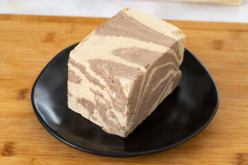 Halva with tahini and cocoa on wooden background. Local name kakaolu ve tahinli helva