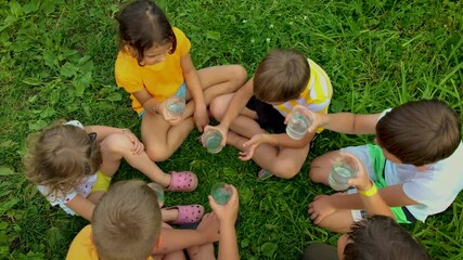 Children together drink water from a glass. Selective focus.