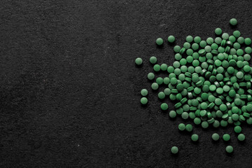 Spirulina pills background. Green tablets superfood.