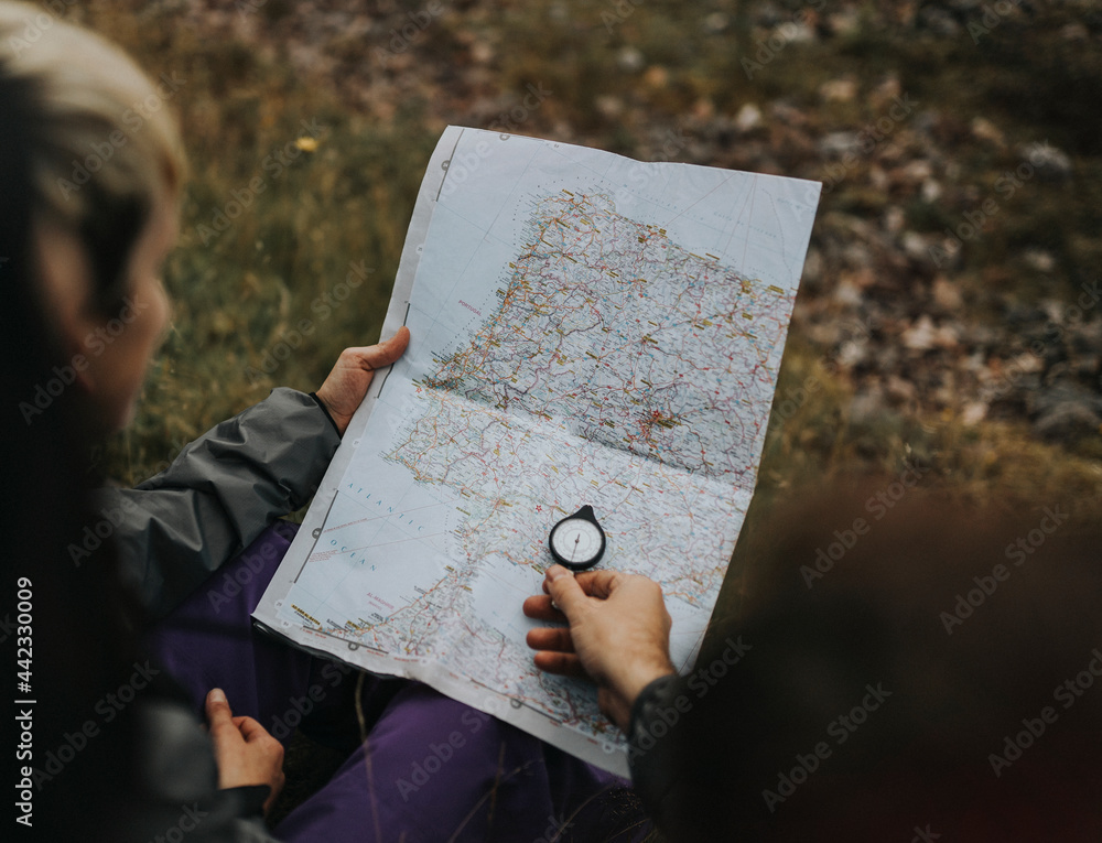 Poster hikers using a compass and a map