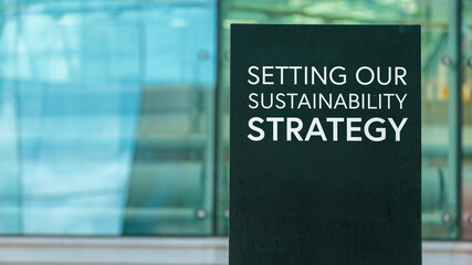 Setting our sustainability strategy  on a city-center sign in front of a modern office building	
