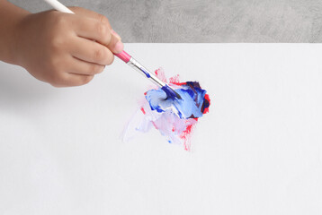 Asian boy use paintbrush and watercolor painting in paper
