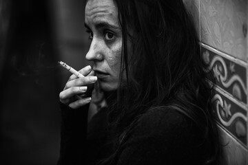 Woman smoking cigarette alone grayscale