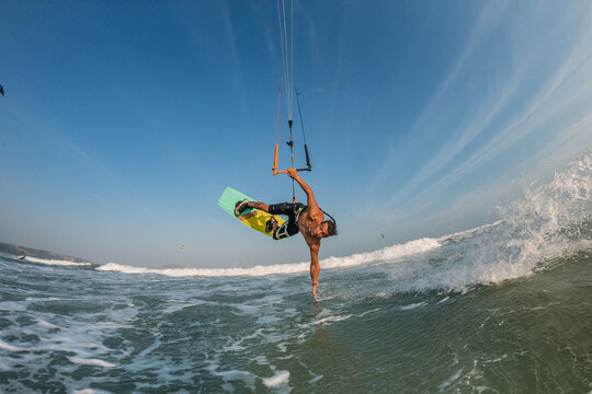 Kite surfer riding a kiteboard on the sea with splash