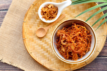 Fried shredded pork in white bowl of bamboo basket - Thai food called Moo Foi at top up view with copy space